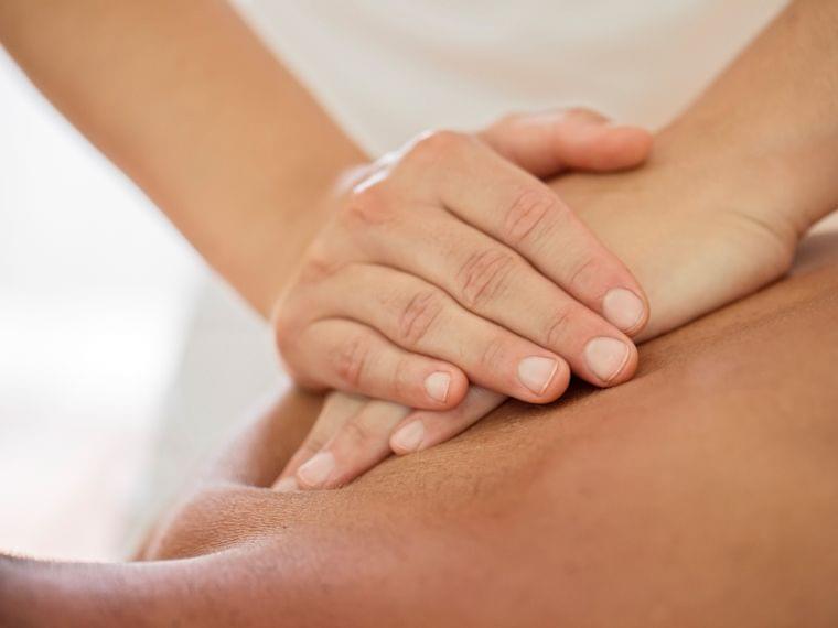 Therapist performing deep tissue massage on a person's back