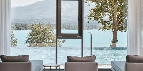 Luxuriöser Spa-Loungebereich mit Seeblick, Infinity-Pool und Berglandschaft durch große Fenster