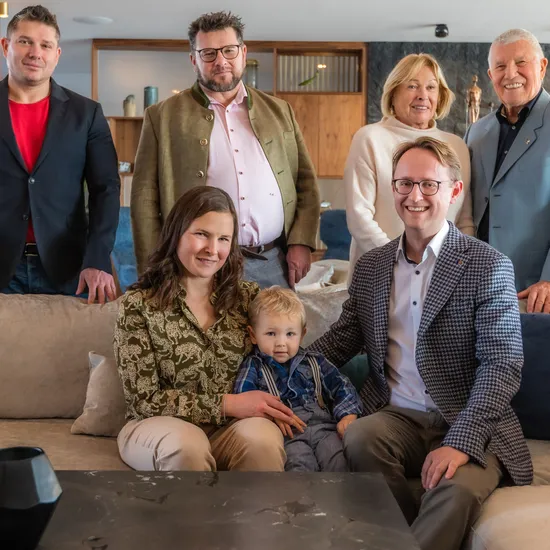 Multi-generational family posing in a modern living room with cozy decor