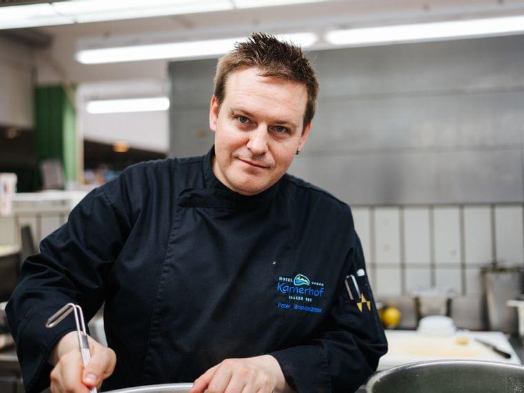 Chef in divisa nera che cucina in una cucina professionale