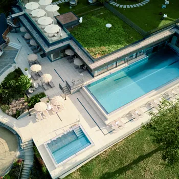 Luxury hotel rooftop with pool, sun loungers, green roof, and landscaped garden view