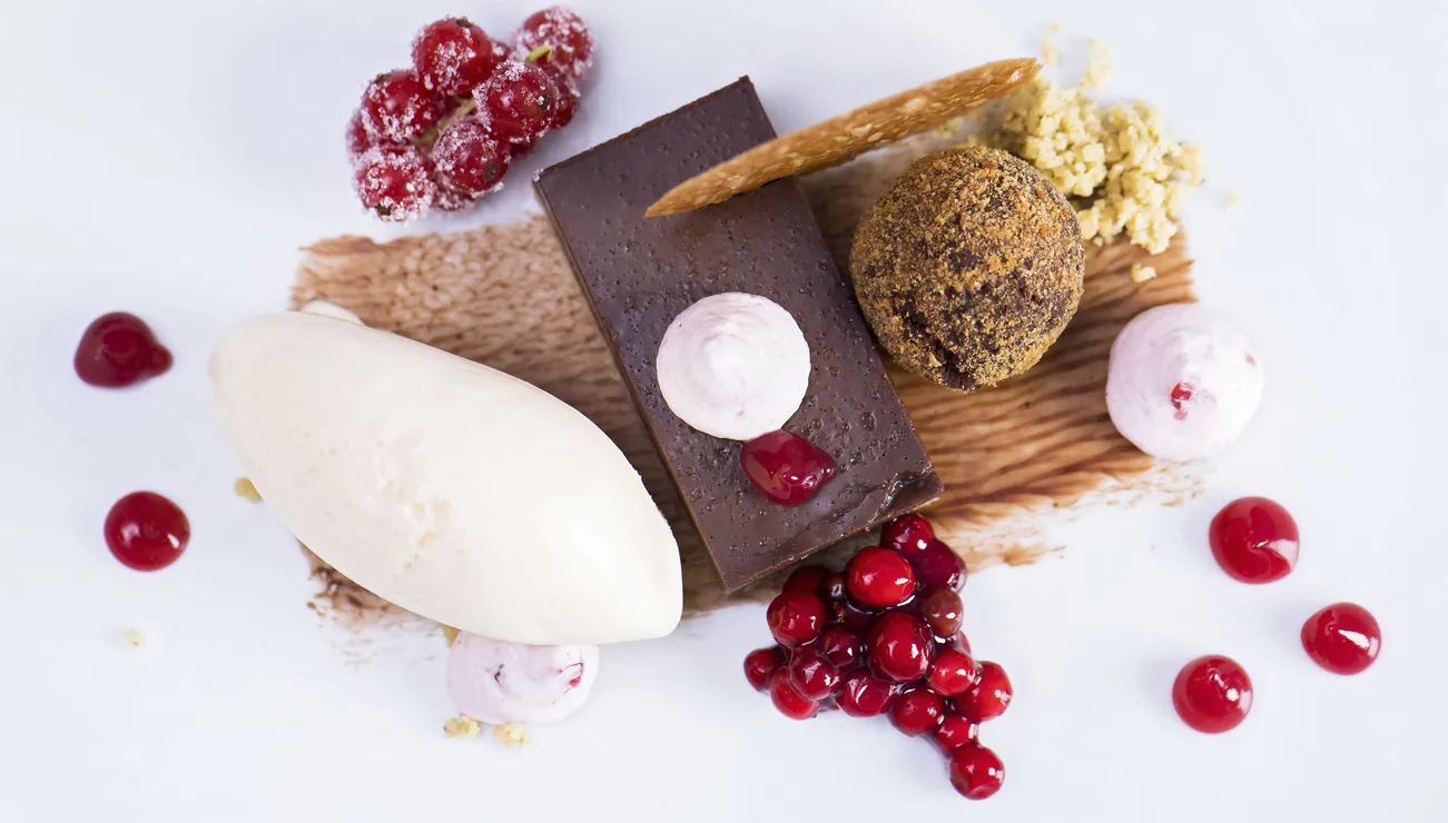 Gourmet-Schokoladendessert mit Eis, Johannisbeeren, Mousse und Streuseln