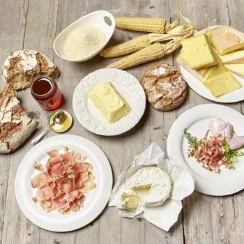 Auswahl an Südtiroler Spezialitäten mit Käse, Brot, Schinken, Butter, Mais und Honig