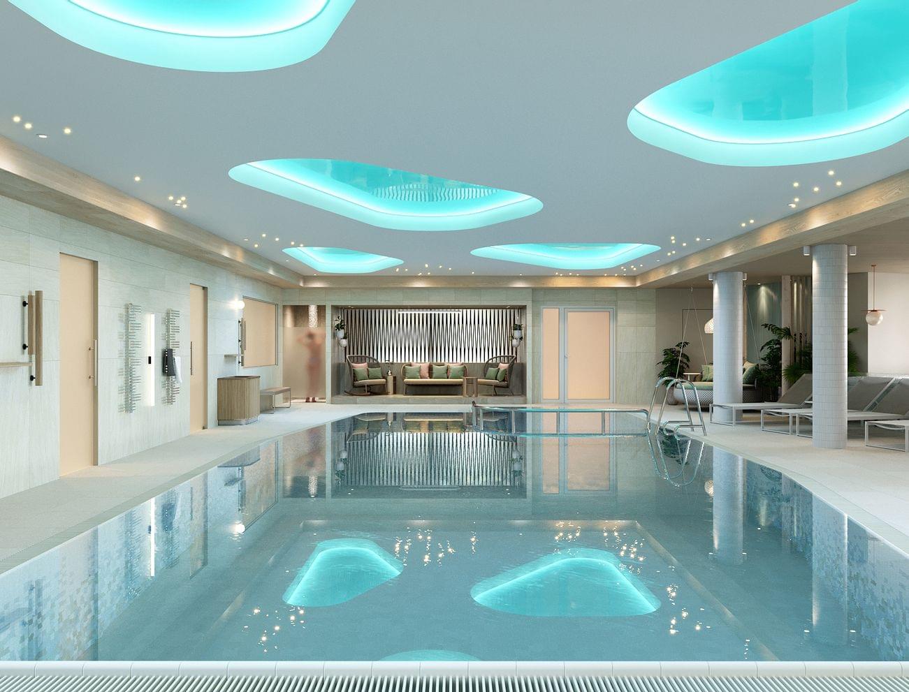 Luxuriöser Innenpool im Spa mit Liegestühlen, stimmungsvoller Beleuchtung und modernem Design