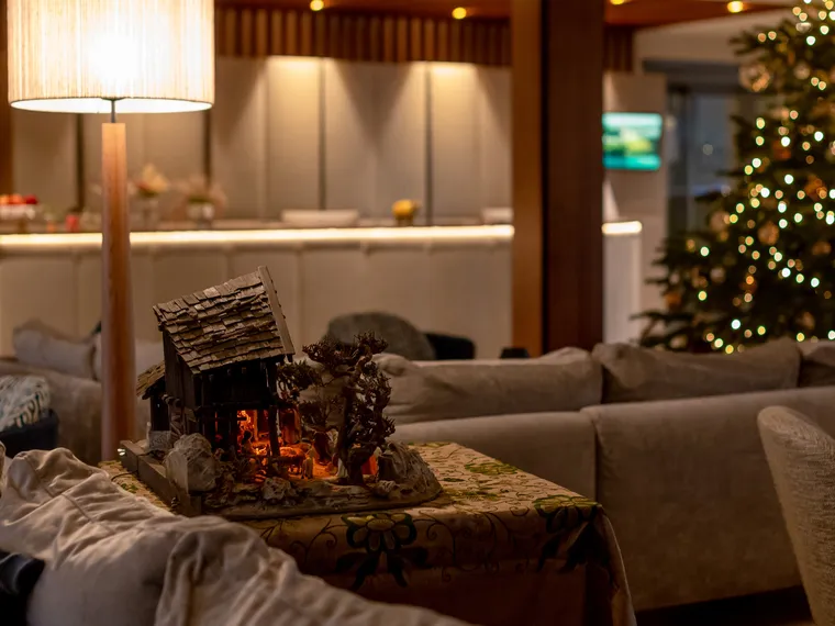 Gemütliche Hotellobby mit Weihnachtsbaum, Tischlampe und Krippendekoration