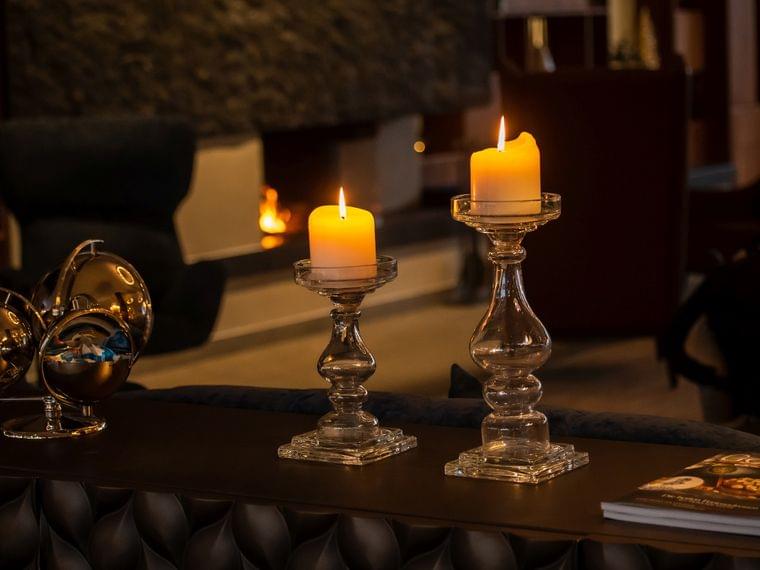 Brennende Kerzen auf Glasständern in gemütlicher Hotellounge mit modernem Design