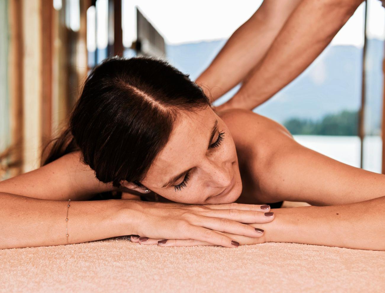 Entspannte Frau erhält Rückenmassage im Spa mit Bergblick