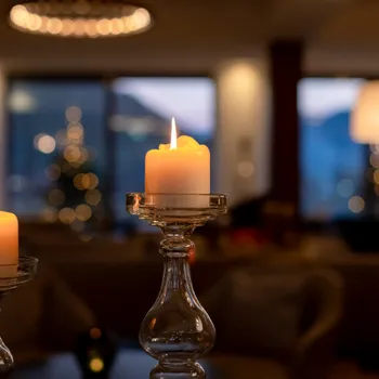 Brennende Kerzen in eleganten Glashaltern mit gemütlicher Innenraumstimmung am Abend