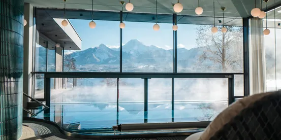 Infinity-Innenpool mit Panoramablick auf Berge in modernem Spa-Resort