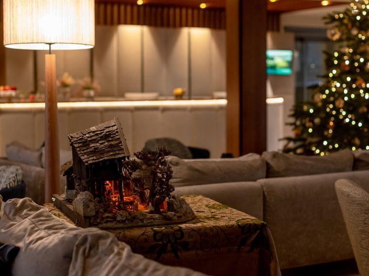 Gemütliche Hotellobby mit Weihnachtsbaum, Tischlampe und Krippendekoration