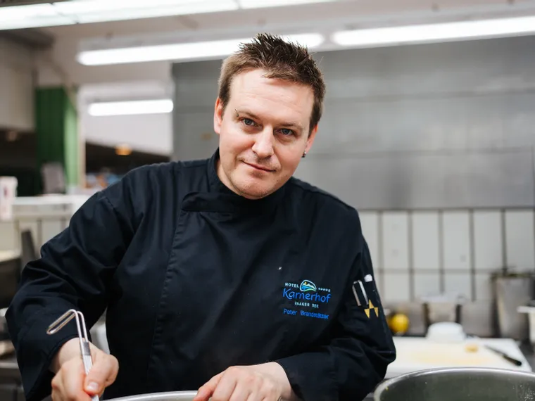 Chef in divisa nera che cucina in una cucina professionale