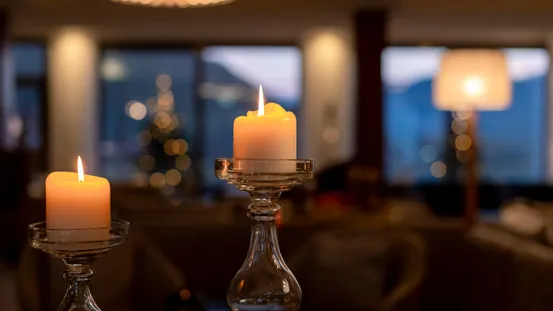 Brennende Kerzen in eleganten Glashaltern mit gemütlicher Innenraumstimmung am Abend