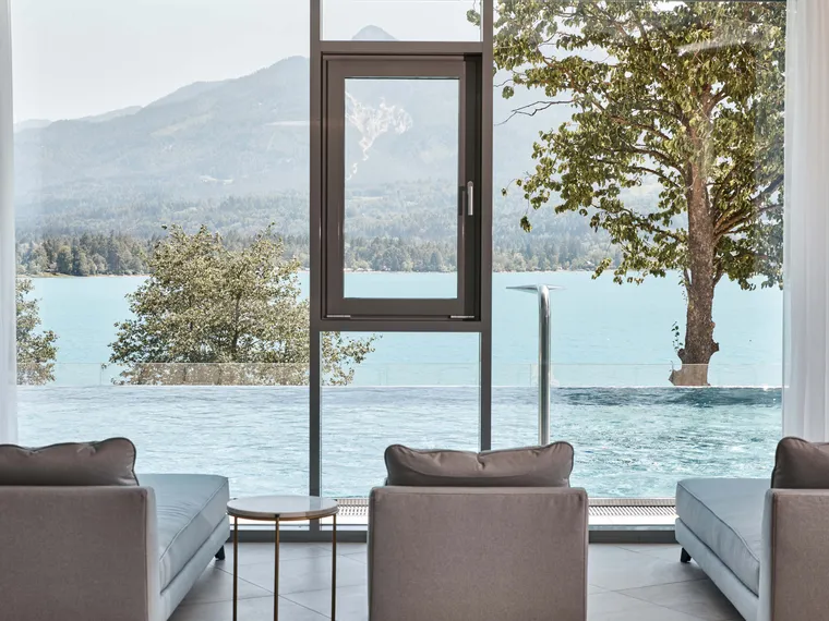 Luxuriöser Spa-Loungebereich mit Seeblick, Infinity-Pool und Berglandschaft durch große Fenster