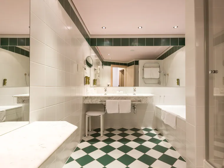 Modernes Badezimmer mit Marmorwaschtisch und grün-weißem Fliesenboden