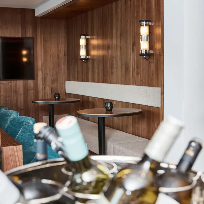 Chilled wine bottles in ice bucket with modern lounge seating in background