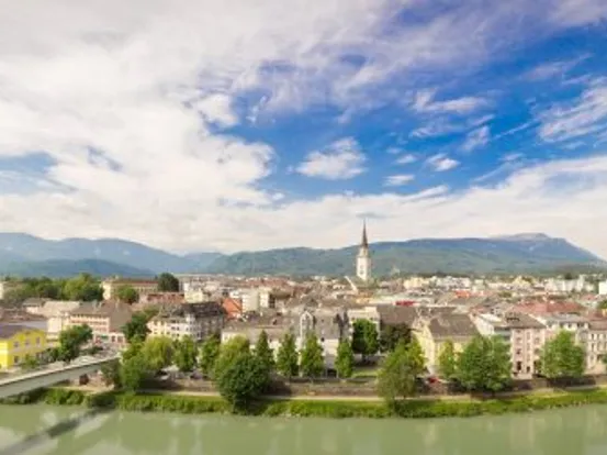 Panorama von Villach in Österreich mit Bergen im Hintergrund und Drau im Vordergrund