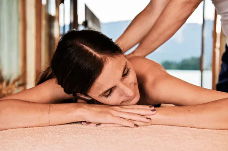 Donna rilassata riceve un massaggio alla schiena in una spa con vista montagna
