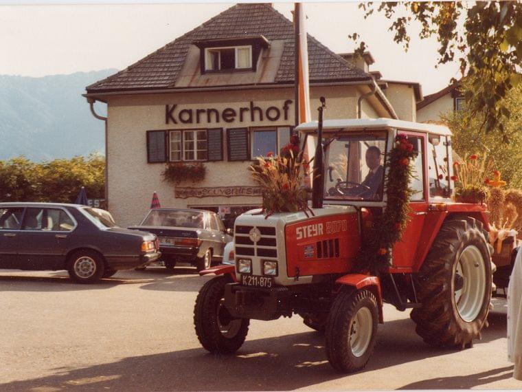 Decorated Steyr 8070 tractor in front of Karnerhof during a festive parade