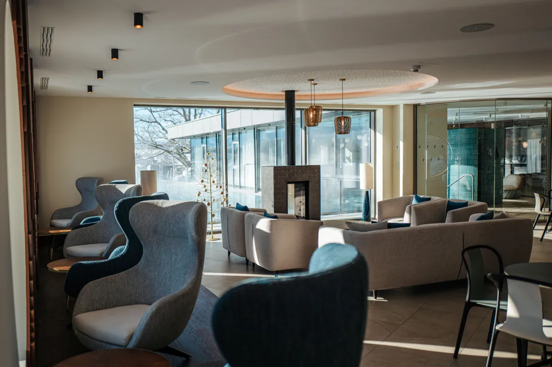Moderne Hotellounge mit stilvollen Sesseln, Kamin und großen Fenstern