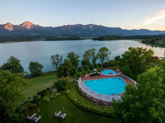 Außenpool eines Hotels mit Blick auf See und Berge bei Sonnenuntergang