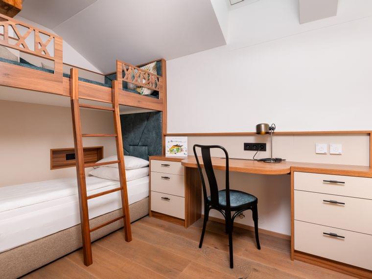 Modernes Kinderzimmer mit Etagenbett aus Holz, Schreibtisch, Stuhl und eingebauten Schubladen