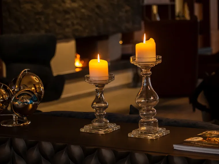 Brennende Kerzen auf Glasständern in gemütlicher Hotellounge mit modernem Design