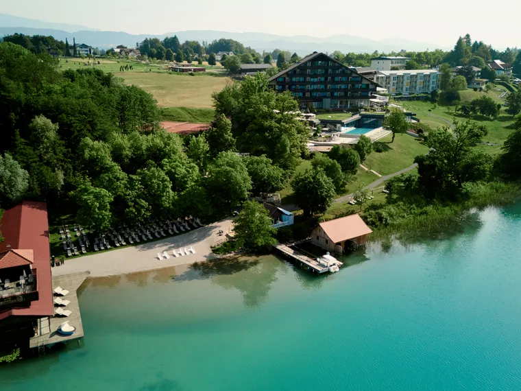 See-Resort mit Privatstrand, Steg und von Wald umgeben an einem sonnigen Tag