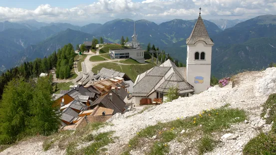 Alpines Bergdorf mit Kirchturm und Panoramablick auf grüne Gipfel