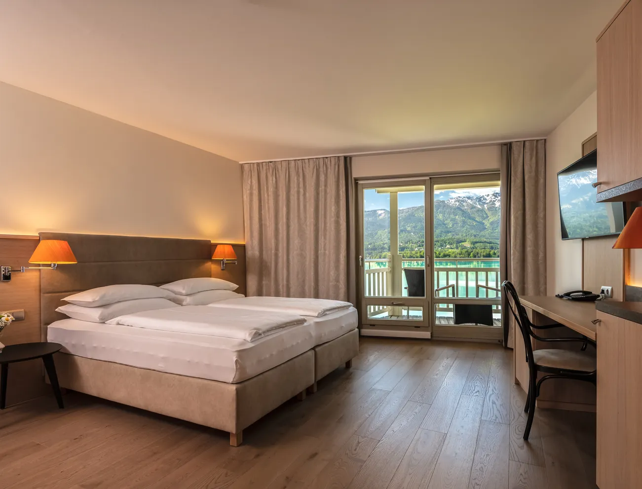 Hotelzimmer mit Doppelbett, Balkonblick auf Berge und See