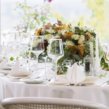 Elegant wedding table setting with white napkins, wine glasses and floral centerpiece