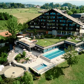 Luxuriöses Wellnessresort mit Außenpool, begrünten Dächern und Bergblick