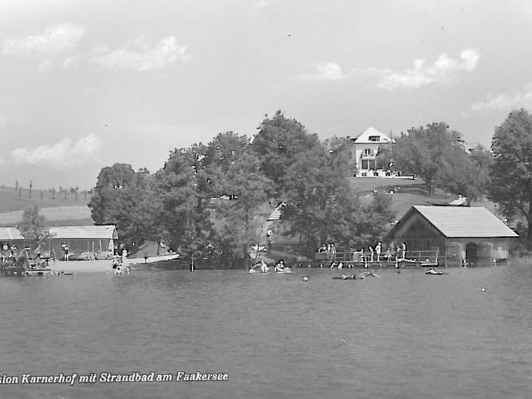 Historic photo of Pension Karnerhof with lakeside beach area at Lake Faaker See