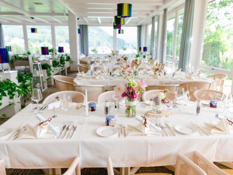 Elegante allestimento per ricevimento di nozze con tovaglie bianche, fiori e luce naturale