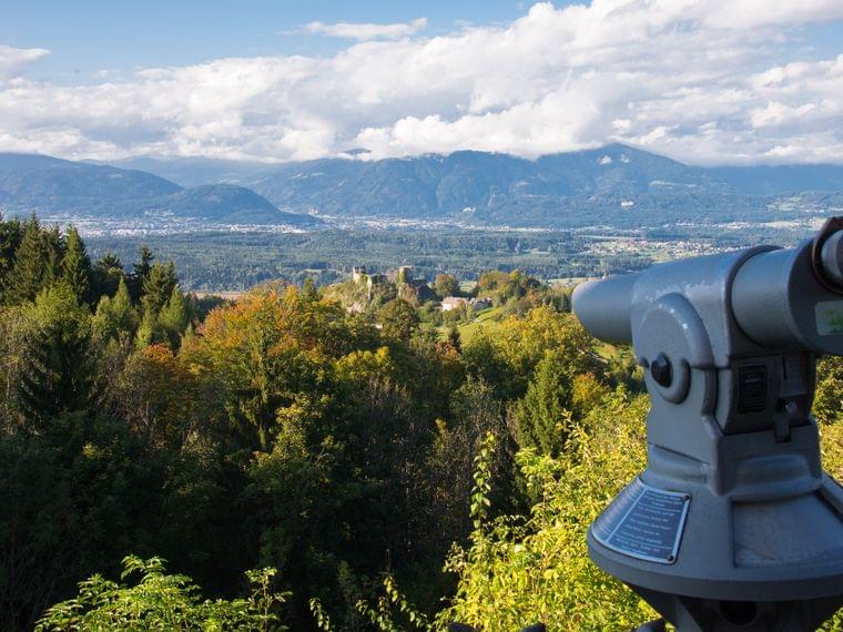 Bergpanorama mit Münzfernrohr und herbstlichem Wald im Vordergrund