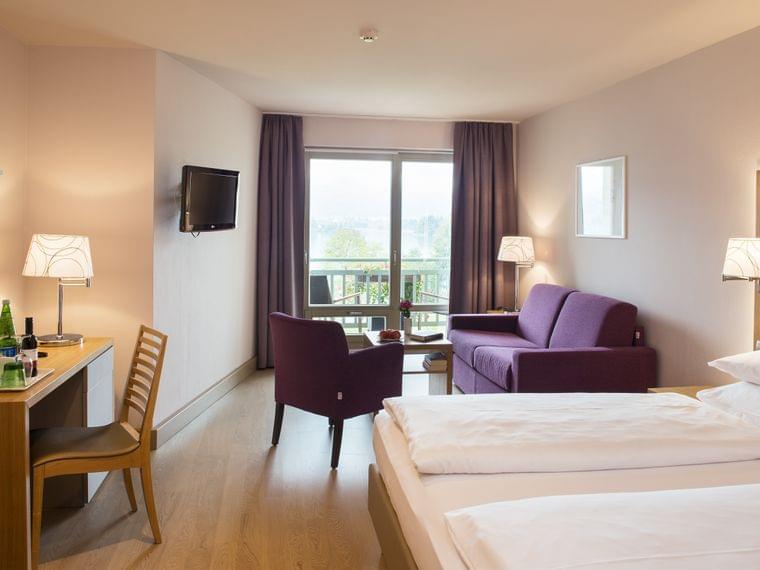 Vier-Sterne-Hotel-Karnerhof-Faaker-See-Oesterreich-Zimmer-Standard-Schreibtisch-Bett-Sitzecke.jpg